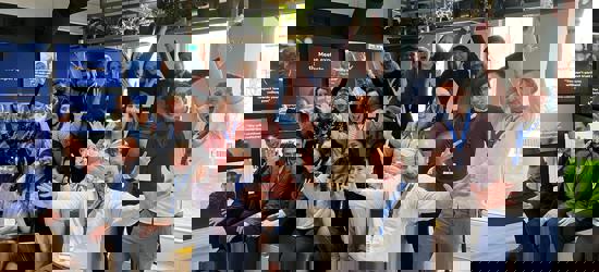 A group of 20 people form all over the world excited and smiling